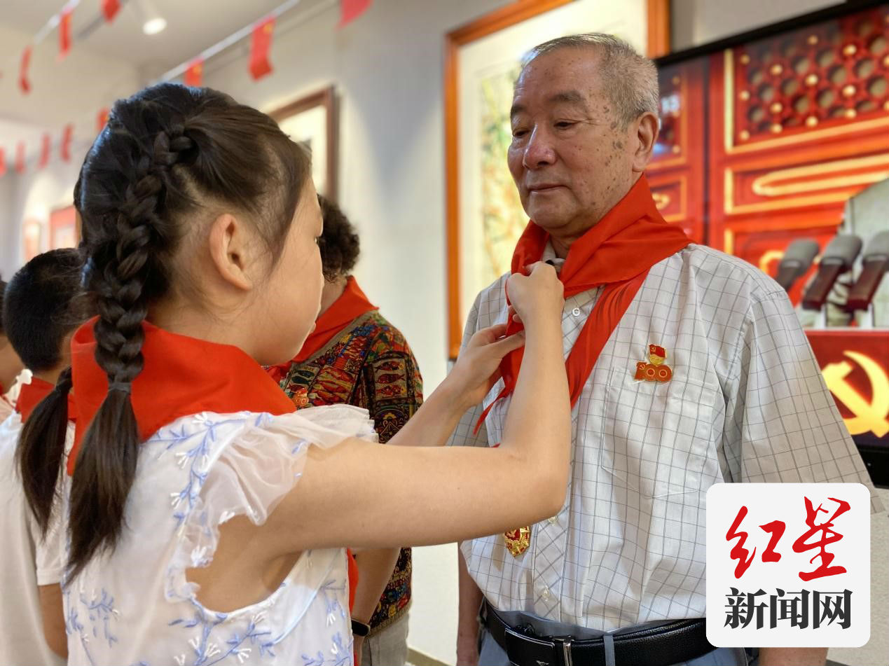 社区成长营的少先队员为老党员佩戴红领巾