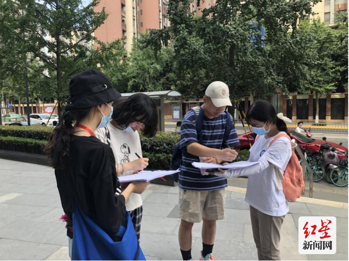 调研队在街头开展问卷调查。 王静 摄