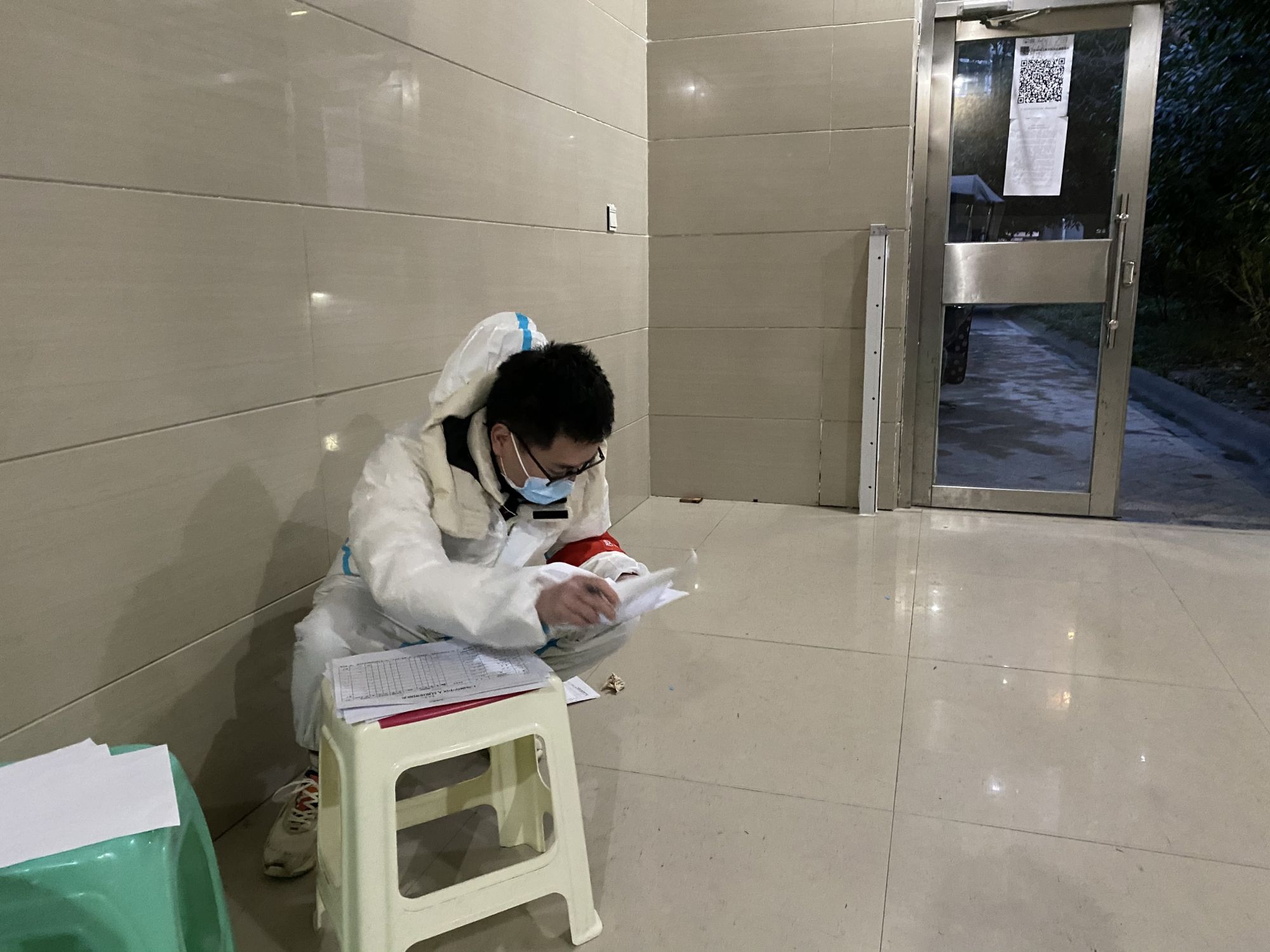 金堂法院法官赵爽在管控区楼道核查防疫登记表格