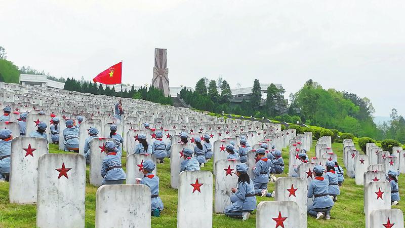 通江县沙溪镇中心小学五年级一班的学生正在为无名烈士纪念园墓碑上的五角星描红。 施皓文 摄