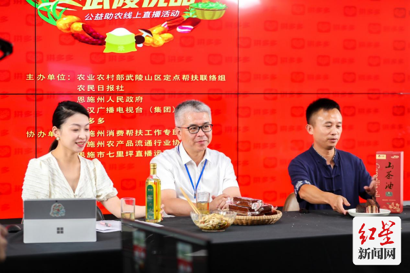 湖南永顺县副县长丁瑞强推介当地特产豆干。 摄影 和际