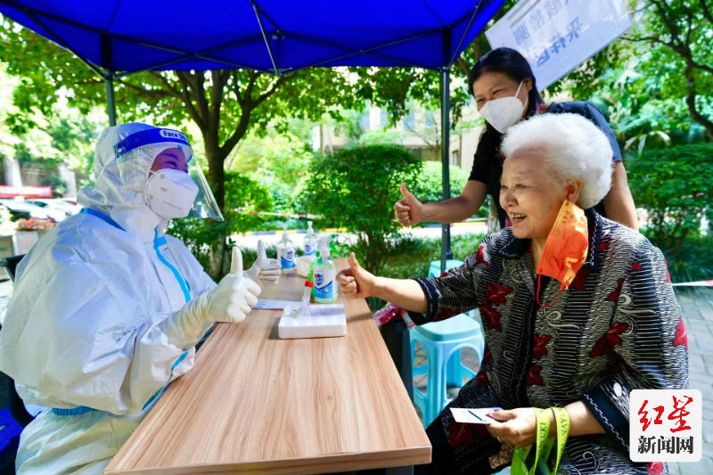 ▲成都市温江区柳城街道光华社区核酸检测点85岁老人林翠英检测完核酸后，为从宜宾珙县中医院支援成都抗疫老师点赞。摄影：梁波