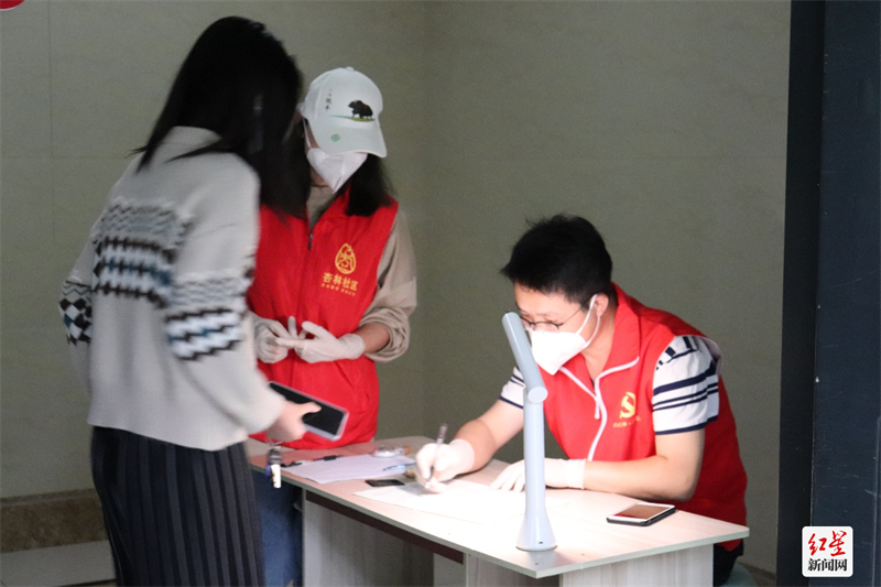 ▲温江区永宁街道杏林社区微网格员刘俊宝做好核酸检测人员登记