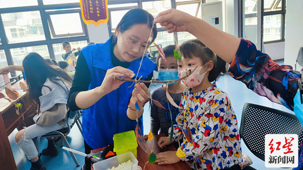 志愿者认真给孩子们讲解如何制作手工挂件