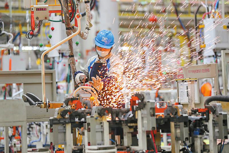 11月25日，宜宾三江新区宜宾凯翼汽车有限公司焊装车间里，工人操作机械臂焊装零件。