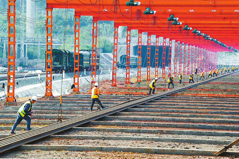11月22日，施工人员在汉巴南铁路巴中东站铺轨基地运输单根500米长、30吨重的长钢轨。截至目前，巴中至南充段路基工程完成94.62%，桥梁工程完成91.5%，隧道工程完成98.5%，这条铁路预计2024年5月底开通。