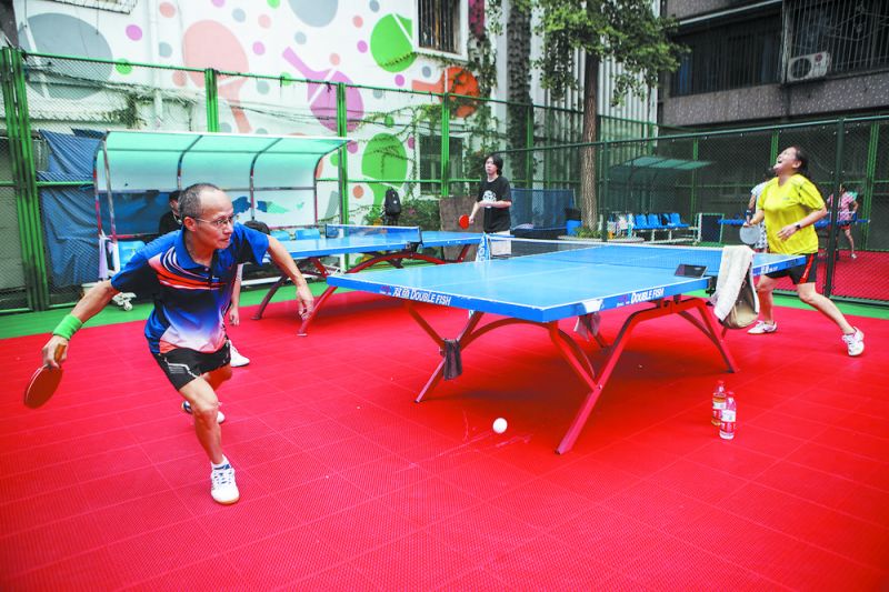 市民在改造一新的社区运动场打乒乓球