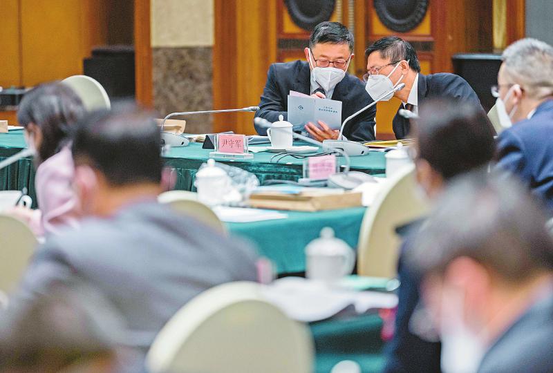 李汉成代表（左）与尹守军代表就《关于四川省2022年预算执行情况和2023年预算草案的报告》中关心的问题进行讨论。