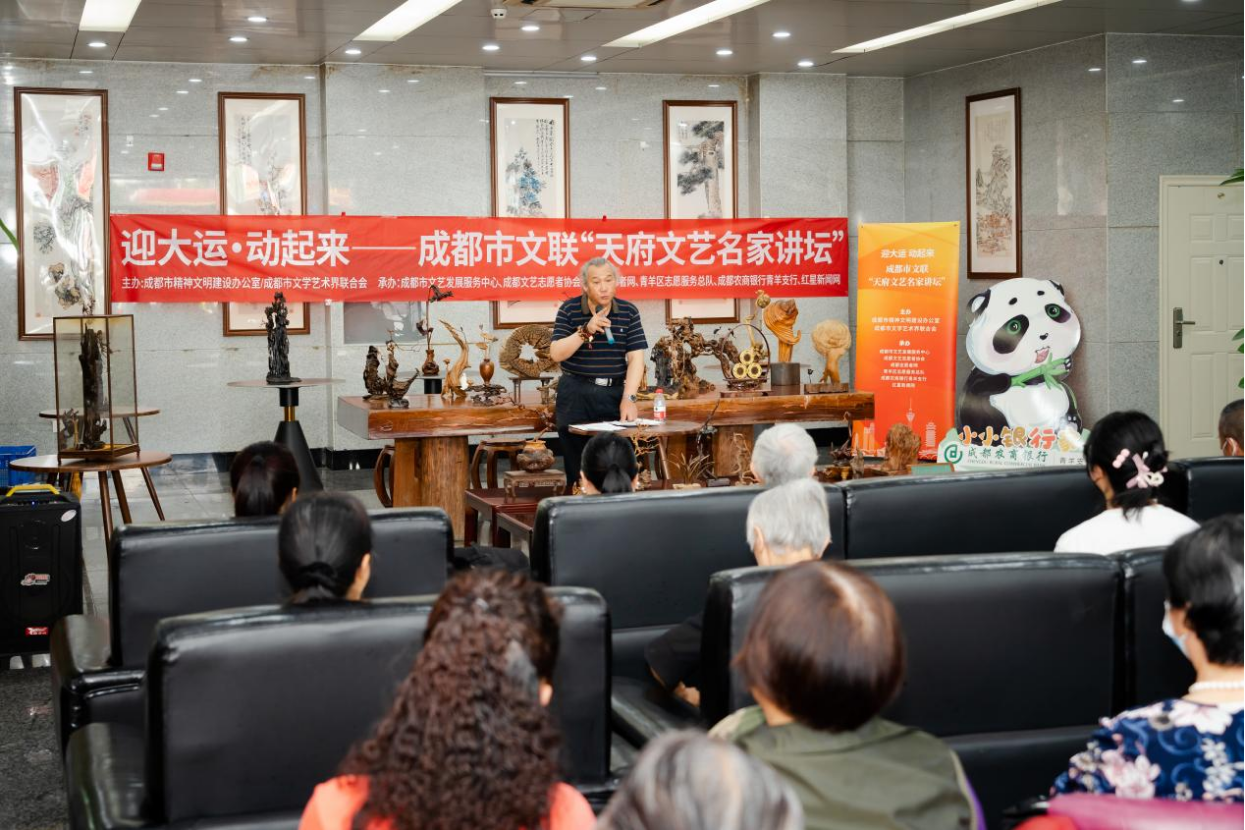 蔡文华向居民介绍根雕技艺