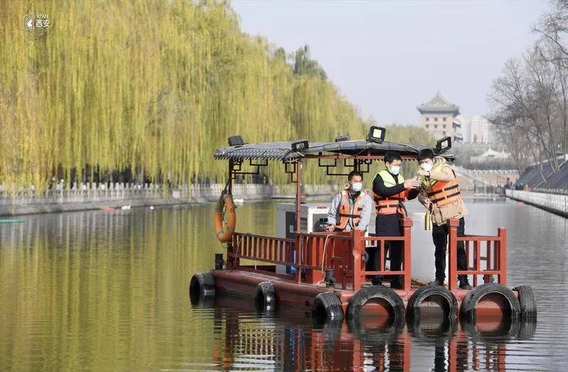 西安护城河管理办级河长韩博武（中）对水质进行取样监测。