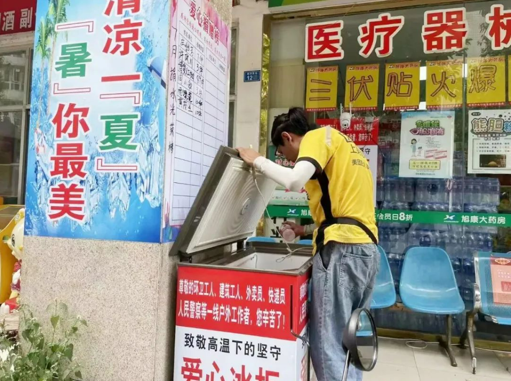 快递小哥在“爱心冰柜”免费取水