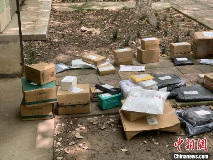 资料图:地面上摆放着快递小哥待投放入快递柜的快递包裹. 康玉湛 摄